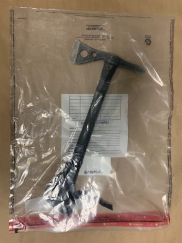 A hatchet is photographed inside a plastic evidence bag