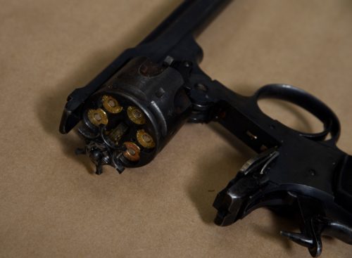 A handgun is opened. Bullets can be seen inside.