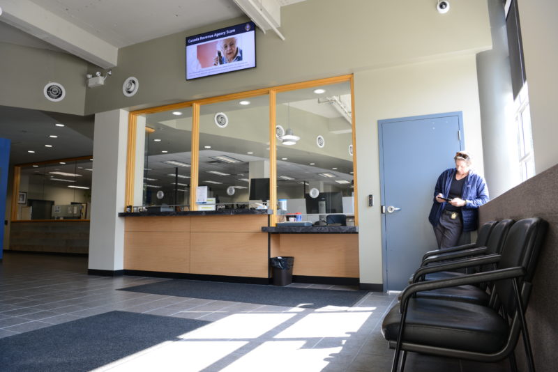 Inside the lobby at the New Westminster Police Department there is seating and a lowered counter. 