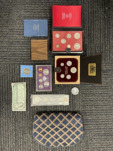 Coins in boxes laid out on a carpet.