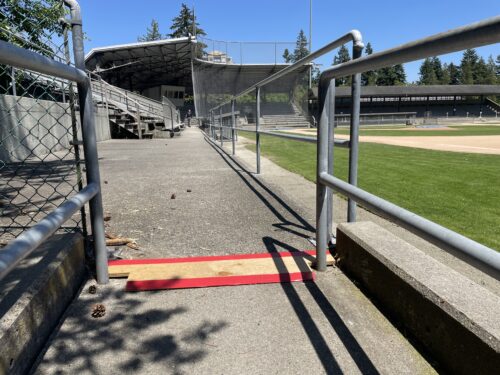 A ramp has a temporary repair made with a piece of wood and red tape.