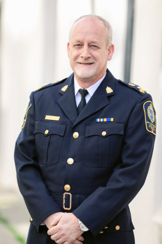 Chief Jansen stands outside the NWPD in uniform.