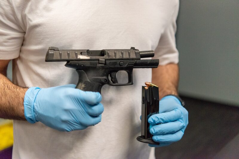 A detective holds a loaded firearm.