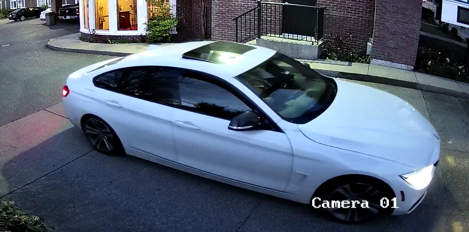 A white 2016 model BMW driving at night.