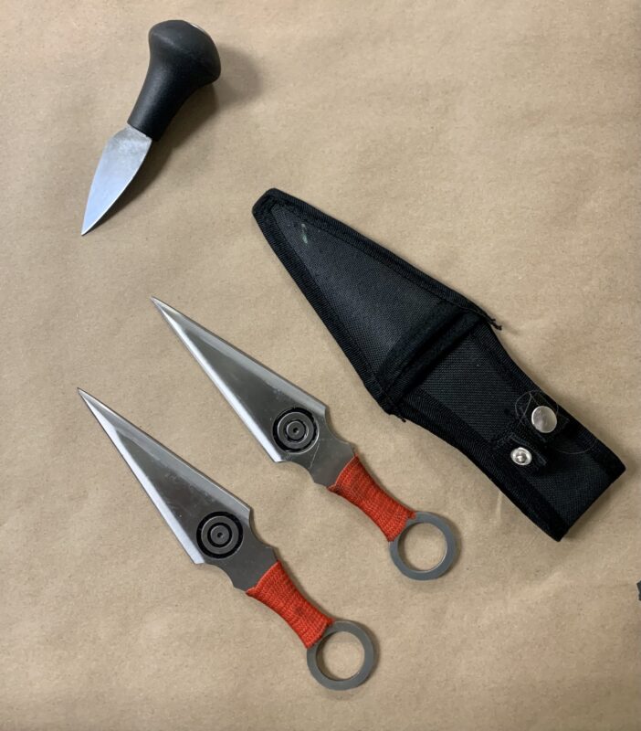 Three knives are photographed on brown paper.