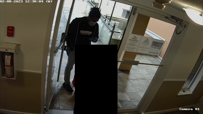 A suspect meets a senior at the front door to a multi-family building. 
